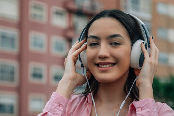 Sticker - smiling young woman with headphones on the street