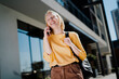 © Jelena - Happy girl walking on the street using the phone. Beautiful blonde girl talking to the smartphone.