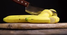 Not Peeled Ripe Yellow Banana Cut Into Pieces On A Board