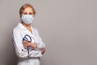 © millaf (Nemchinova) - Female physician wearing in uniform and protective medical mask on grey background