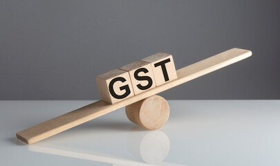 Poster - GST on wooden cubes on a wooden balance , business concept