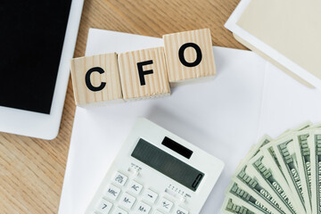 Wall Mural - top view of dollar banknotes near calculator and cubes with cfo lettering.