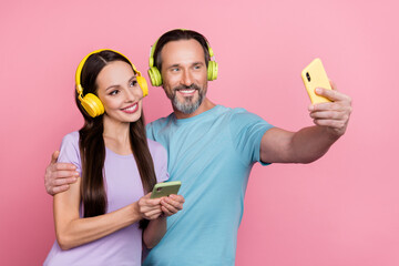 Poster - Photo of lovely married couple have same interests music genre take selfie with headset isolated on pink color background