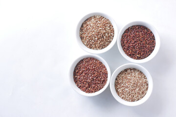 Wall Mural - four different types of rice in a bowl on white background 