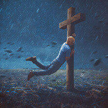Man Clinging To Cross