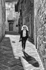 Wall Mural - Young woman walking on a narrow lane In The Center Of San Gimignano, Tuscany, Italy, Europe