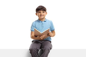 Poster - Child sitting on a blank panel with a book in his hands