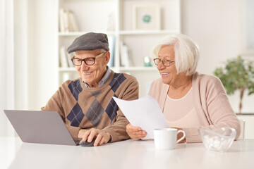 Poster - Happy elderly man and woman holding a document and looking at a laptop computer