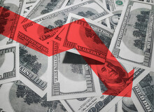 The Large Light Red Arrow Icon On A Background Of Money. The Concept Of Changing Course Of US Dollar On The Market. Devaluation, Collapse, Stagnation Of The Economy.