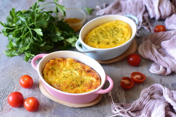 Wall Mural - Healthy breakfast for the whole family: omelette with cheese and fresh herbs in beautiful plates on a gray background. Close-up