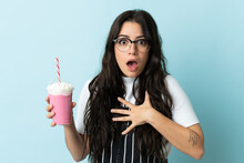 Young Woman With Strawberry Milkshake Isolated On Blue Background Surprised And Shocked While Looking Right