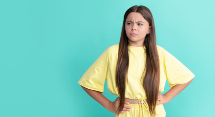 serious teen girl with long hair on blue background, fashion