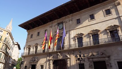 Wall Mural - Facade of Town hall of Palma de Mallorca with Flags of Spain, Balearic Islands, Catalonia and European Union waving in the wind - Spain