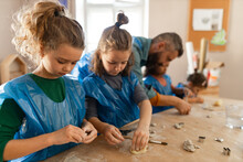 Group Of Little Kids With Teacher Working With Pottery Clay During Creative Art And Craft Class At School.