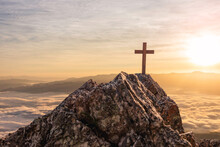 Silhouettes Of Crucifix Symbol On Top Mountain With Bright Sunbeam On The Colorful Sky Background
