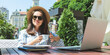 Woman drinking coffee in outdoor cafe.