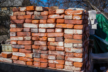 A Pile Of Building Materials, Stack Of New Red Bricks For Construction Are Accurately Put Together.