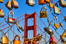 Golden Gate Bridge At Sunset Through Opening In Chain Linked Fence Covered In Locks