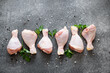 raw chicken legs with spices on a stone background