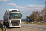Fototapeta  - The truck is moving along a suburban highway. Cargo transportation, logistics.
