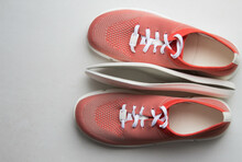 Orange Sport Shoes With Orthopedic Insoles On Neutral Background.. Top View.