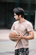 © Success Media - Young causian basketball player shooting ball on street court.
