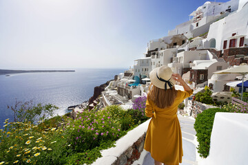 Wall Mural - Amazing resort holiday vacation in Greece. Young beautiful girl walking in Oia village on Santorini Island, Greece.