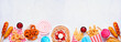 Carnival theme food bottom border on a white marble background. Top view with copy space. Summer fair concept. Corn dogs, funnel cake and snacks.