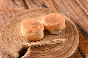 Two loaves of bread on the wooden board.