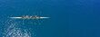 © aerial-drone - Aerial drone top ultra wide panoramic view of sport canoe rowing synchronous team of athletes competing in deep blue sea