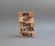 We go the extra mile symbol. Wooden blocks with words 'We go the extra mile'. Beautiful grey background. Business and 'We go the extra mile' concept. Copy space.