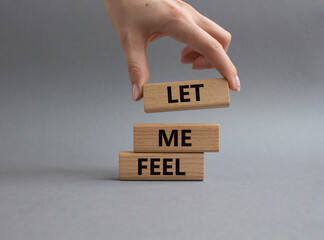 Feel symbol. Wooden blocks with words 'Let me feel'. Beautiful grey background. Businessman hand. Psychology and let me feel concept. Copy space.