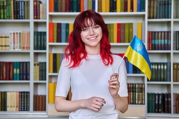 Teenage female student with flag of Ukraine in the library