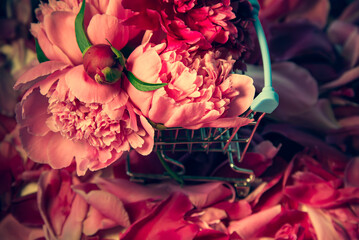 Wall Mural - Flowers and petals on the table in a shopping basket.