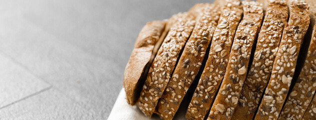 Wall Mural - Bread, traditional sourdough bread cut into slices on a rustic wooden background