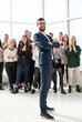 © ASDF - happy businessman standing in front of his team
