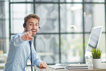 Wall Mural - Man with headphones and laptop working in office