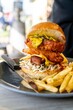 Fried chicken burger and fries with coleslaw and pickles