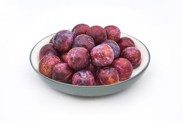 Purple plums on white background