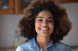 © fizkes - Headshot portrait happy cheering beautiful African American teen female look at camera with toothy hollywood smile make video call. Gen z lady satisfied client shoot video feedback on goods service
