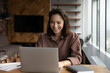 © fizkes - Happy business woman working at home office workplace with computer, chatting online, typing, looking and smiling at screen. Remote employee, female entrepreneur using laptop, making video call