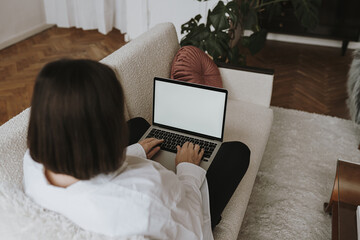 Wall Mural - Aesthetic minimalist home office workspace desk. Woman working on laptop computer. Blank mockup screen template. Work, business concept