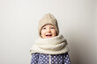 © Alex - beautiful little baby in a hat is surprised on a light background. Concept of children's emotions, winter, shopping