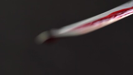 bloody knife with blood dripping on black background