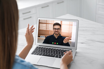 Poster - Woman talking with handsome man using video chat on laptop at white marble table, closeup. Online dating