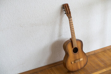 spanish guitar on a old chair with wooden background horizontal