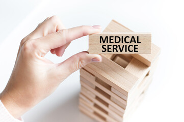 Wall Mural - the words MEDICAL SERVICE are written on a wooden cubes structure. Can be used for business, financial, MEDICAL concept. Selective focus.