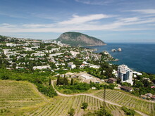 Aerial Panoramic View On Gurzuf Resort City And Bear Mountain, Ayu-Dag, Yalta, Crimea. Spring Sunny Day. Nature Summer Ocean Sea Beach Background. Vacation, Travel And Holiday Concept.