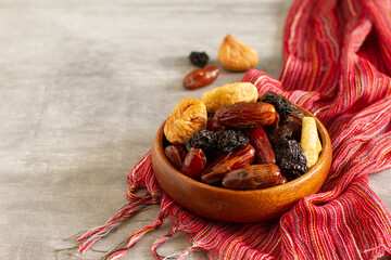 Wall Mural - Dried fruits and berries on a wooden bowl . Raisins, nuts, cherries, plums, dried apricots, dates, pineapples, figs, bananas.