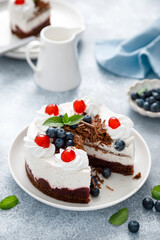 Wall Mural - Chocolate cake, white cheesecake decorated with blueberries, cherry, brown chocolate and whipped cream